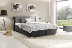 Dvojlôžko Juve v rozmere 180x200 cm, v poťahu Loft Grey a Prima 13 Grey, s prikrývkou a vankúšikmi v poťahu Santos Duo 1A, interiér